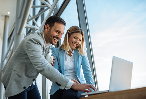 a woman and a man looking at a computer