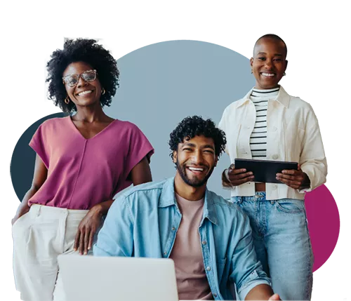 two people standing smiling and one sitting with the computer smiling