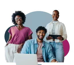 two people standing smiling and one sitting with the computer smiling