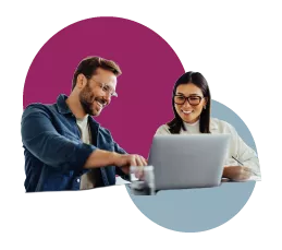  Man pointing at computer screen while colleague looks on smiling